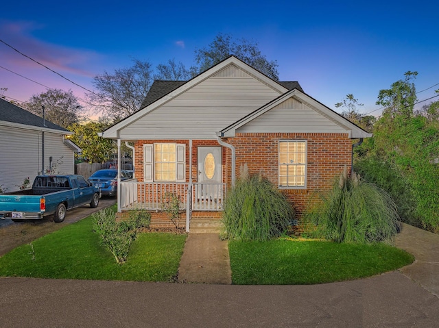 bungalow-style house featuring a porch and a yard