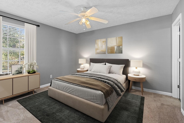 carpeted bedroom with ceiling fan and a textured ceiling