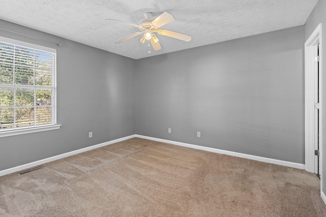 carpeted spare room with a textured ceiling and ceiling fan