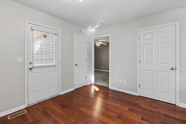 foyer entrance featuring dark wood-type flooring and a textured ceiling