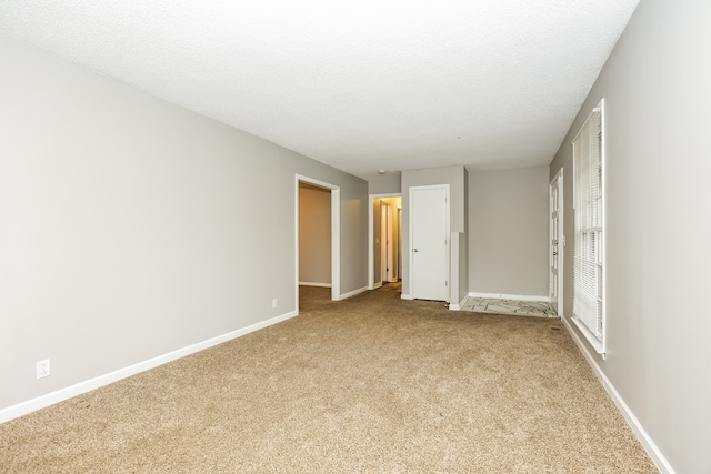 unfurnished bedroom with a textured ceiling and light carpet