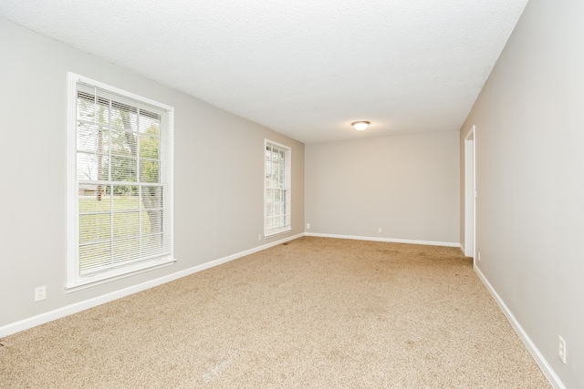 carpeted empty room featuring a textured ceiling