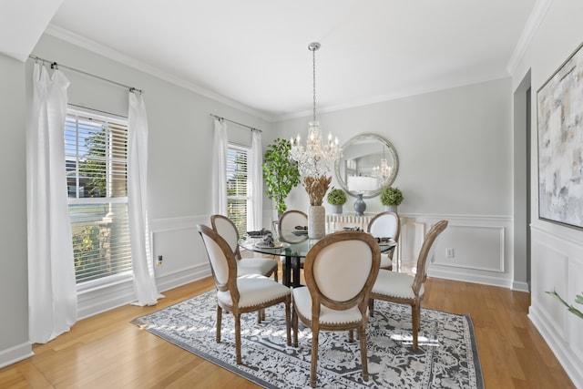 dining space featuring a chandelier, crown molding, and light hardwood / wood-style flooring