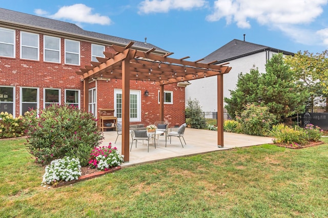 rear view of property featuring a yard, a pergola, and a patio area