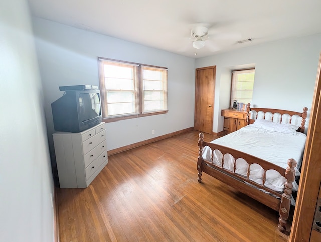 bedroom with multiple windows, ceiling fan, and light hardwood / wood-style flooring