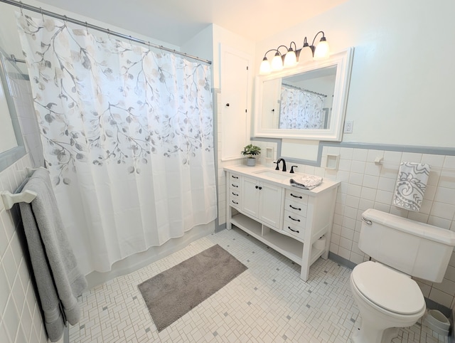 full bathroom featuring shower / bath combo, tile patterned floors, vanity, toilet, and tile walls