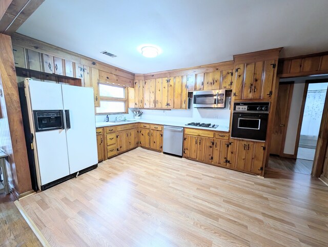 kitchen with appliances with stainless steel finishes, light hardwood / wood-style floors, and sink