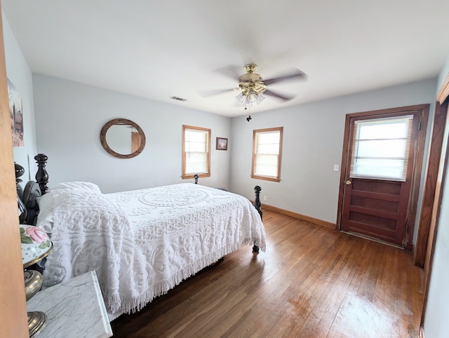 bedroom with hardwood / wood-style flooring, ceiling fan, and multiple windows