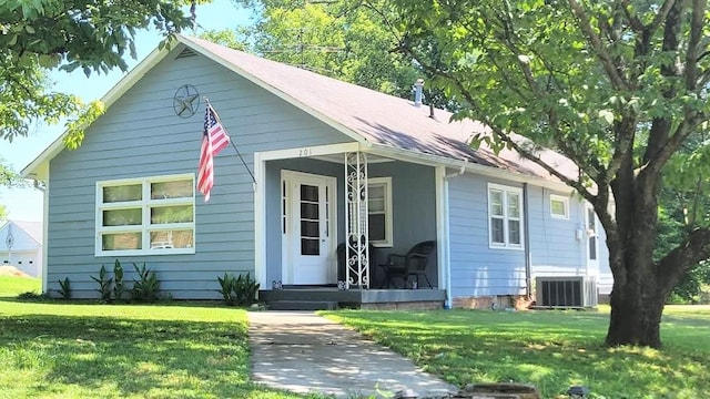 bungalow-style house with central AC unit and a front yard