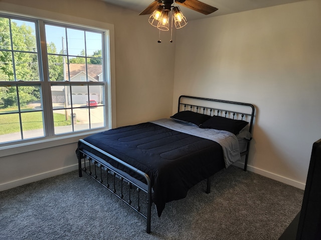 carpeted bedroom featuring ceiling fan and multiple windows