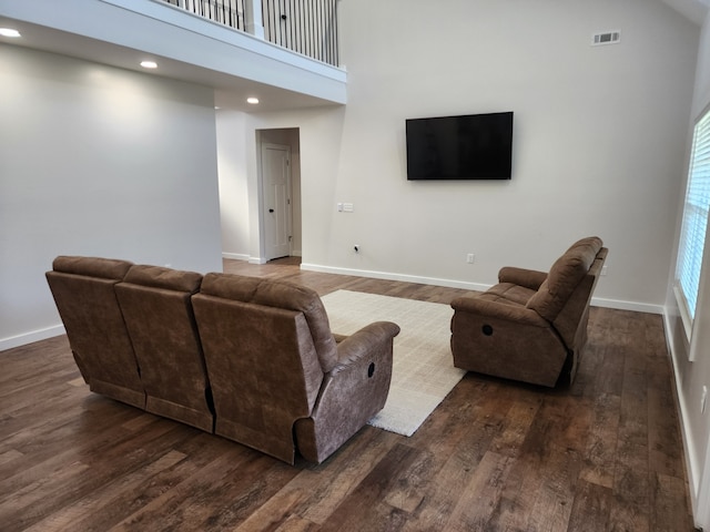 living room featuring a high ceiling and dark hardwood / wood-style floors