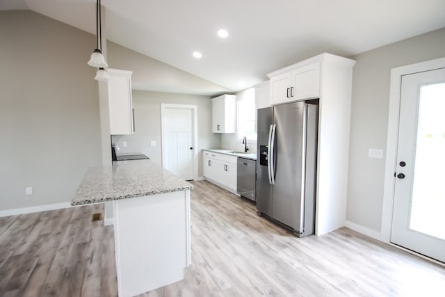 kitchen featuring white cabinets, sink, vaulted ceiling, appliances with stainless steel finishes, and light stone countertops