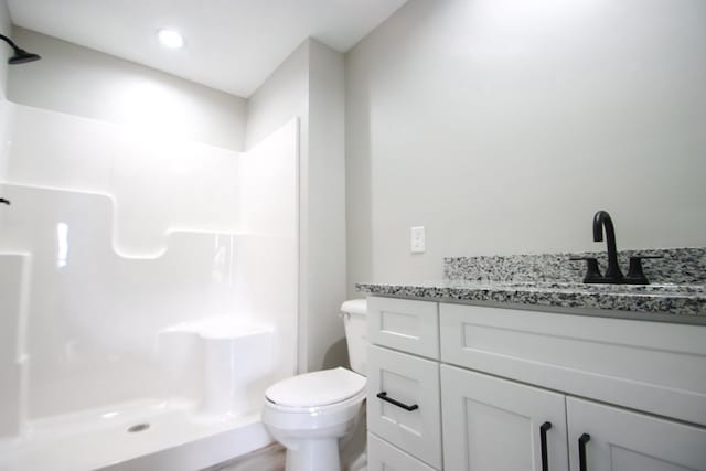 bathroom with vanity, toilet, and walk in shower