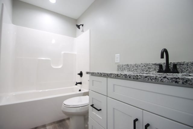 full bathroom with vanity, hardwood / wood-style floors, toilet, and shower / washtub combination