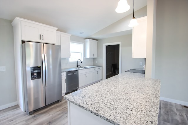 kitchen with decorative light fixtures, white cabinets, sink, and stainless steel appliances