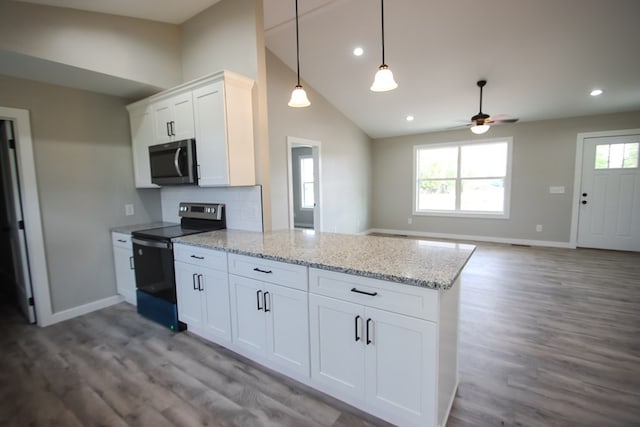 kitchen featuring kitchen peninsula, white cabinets, stainless steel appliances, and wood-type flooring