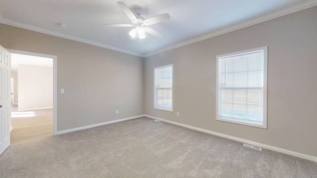 spare room with light colored carpet, ceiling fan, and crown molding