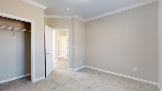 unfurnished bedroom featuring light colored carpet, a closet, and crown molding