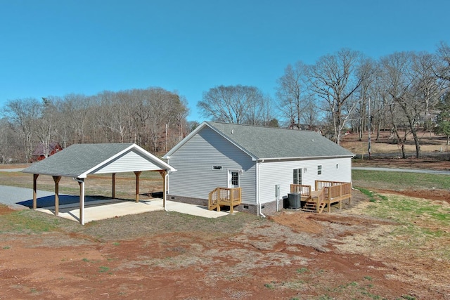 back of house with a wooden deck, central AC, and a carport