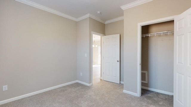 unfurnished bedroom featuring crown molding, a closet, and light colored carpet