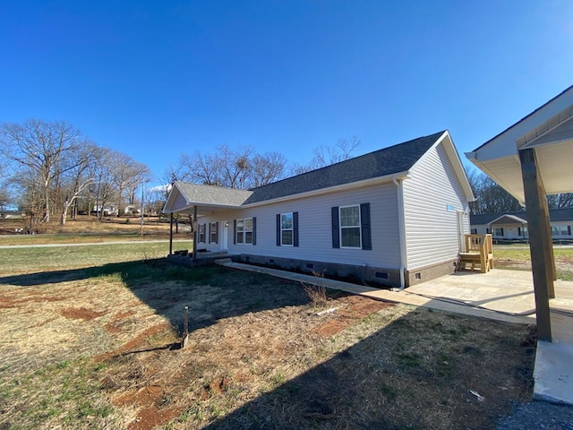 view of side of home with a lawn and a patio