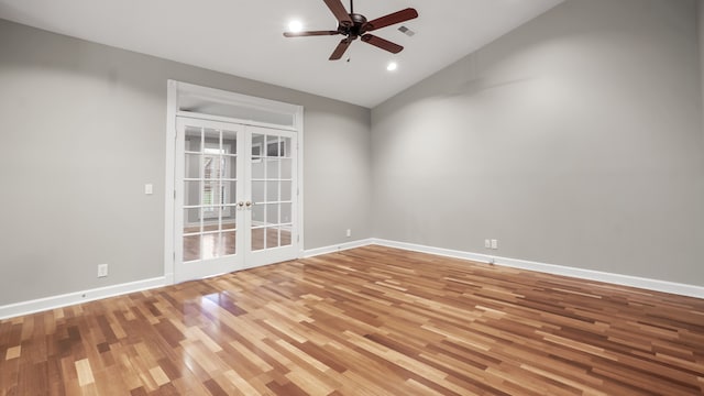 empty room with hardwood / wood-style floors, ceiling fan, lofted ceiling, and french doors