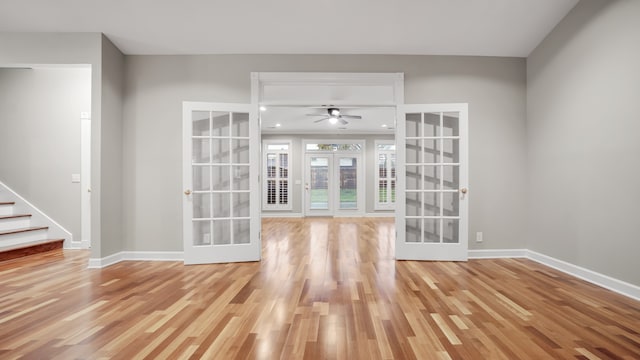 unfurnished living room featuring french doors, hardwood / wood-style flooring, and ceiling fan