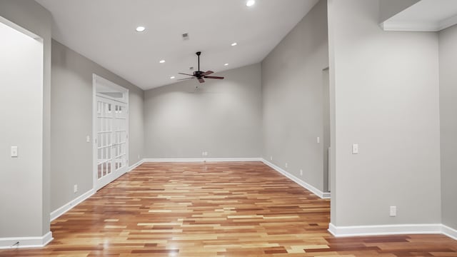 empty room with lofted ceiling, ceiling fan, and light wood-type flooring