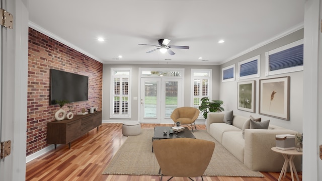 living room featuring ceiling fan, french doors, brick wall, light wood-type flooring, and ornamental molding