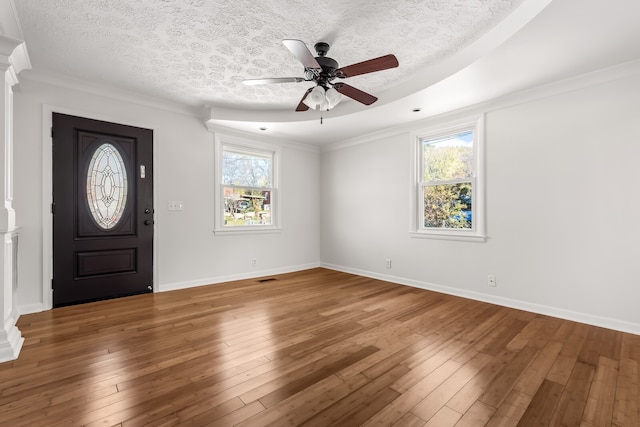 entrance foyer with a textured ceiling, hardwood / wood-style flooring, plenty of natural light, and ornamental molding