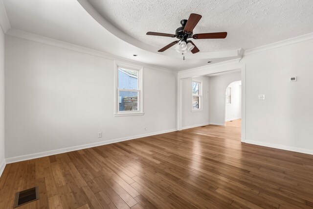 spare room with wood-type flooring, a textured ceiling, ceiling fan, and crown molding