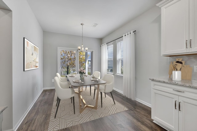 dining room featuring dark wood-type flooring and an inviting chandelier