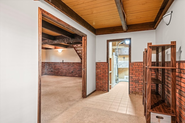 hallway with brick wall, beamed ceiling, wood ceiling, and light colored carpet