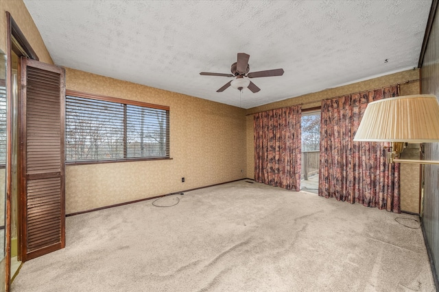 unfurnished bedroom featuring ceiling fan, carpet floors, and a textured ceiling