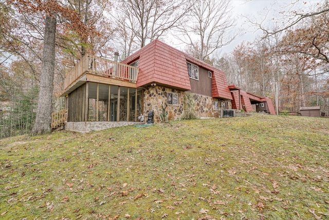 back of property with a yard, central AC unit, and a sunroom