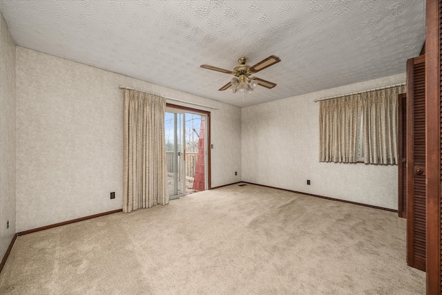 spare room featuring ceiling fan, carpet floors, and a textured ceiling