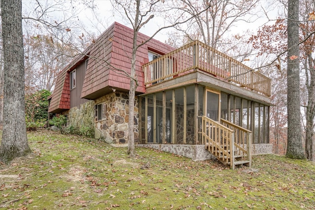 back of house featuring a yard and a sunroom