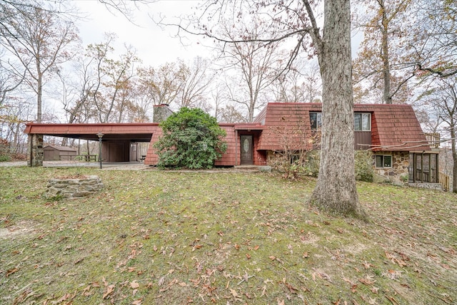 rear view of house with a lawn and a carport