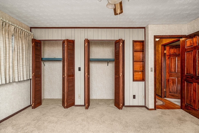 unfurnished bedroom featuring ceiling fan, light carpet, and a textured ceiling