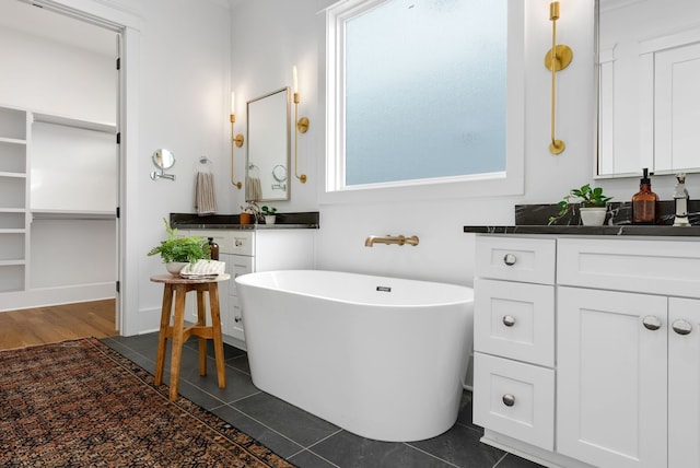 bathroom with vanity, a tub to relax in, and tile patterned flooring