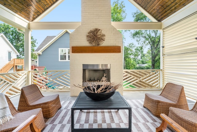 wooden deck featuring an outdoor brick fireplace