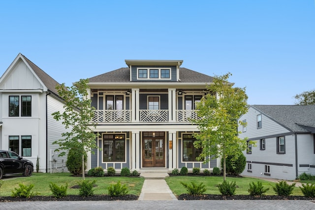 view of front of house featuring a front lawn and a balcony