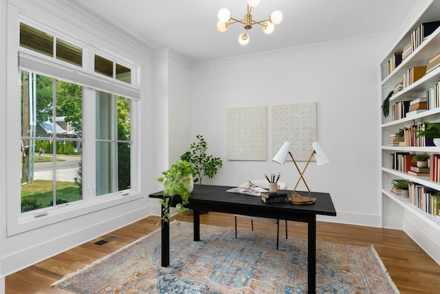 office space featuring wood-type flooring, crown molding, and an inviting chandelier