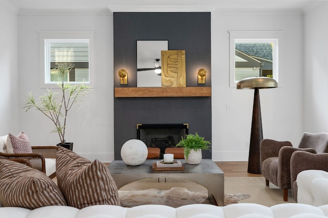 living room with ornamental molding, a wealth of natural light, and light wood-type flooring