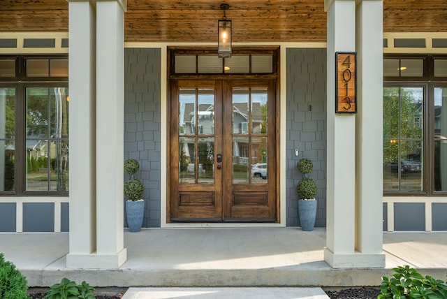 entrance to property with covered porch and french doors