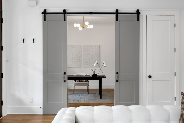 interior space with hardwood / wood-style flooring, a barn door, and an inviting chandelier