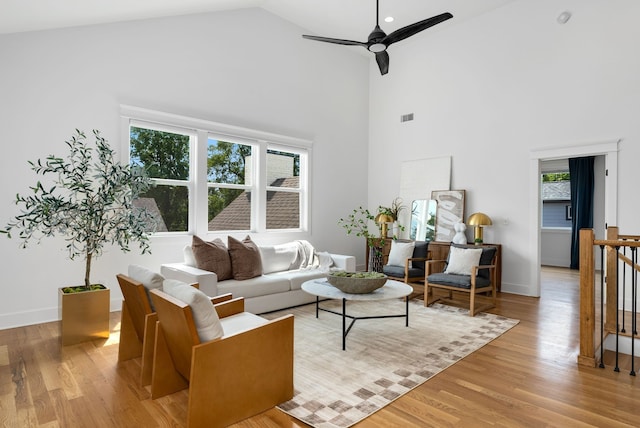 living room featuring high vaulted ceiling, light hardwood / wood-style flooring, and ceiling fan