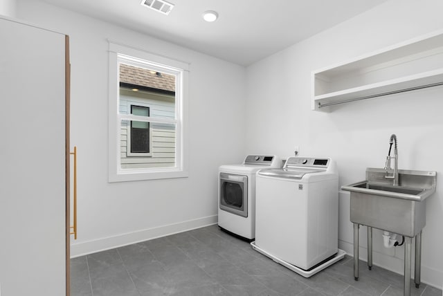 laundry area with independent washer and dryer and sink