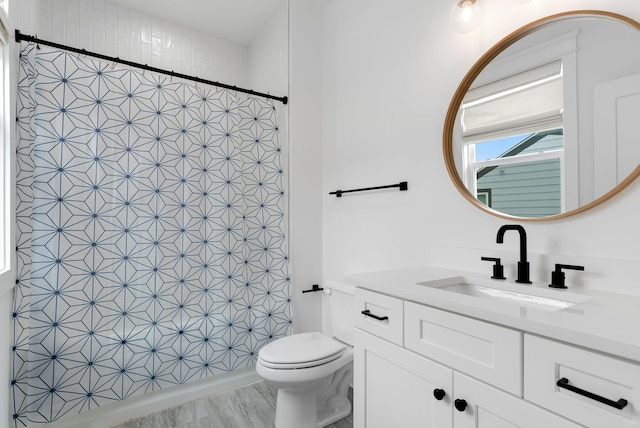 bathroom featuring hardwood / wood-style floors, vanity, toilet, and tile walls