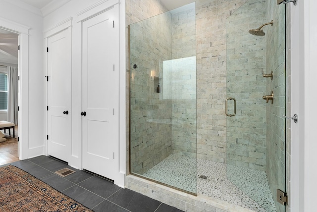 bathroom with tile patterned flooring, walk in shower, and ornamental molding